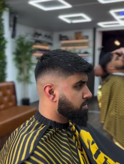 Textured crop with a clean fade and shaped beard at Lion Barbers